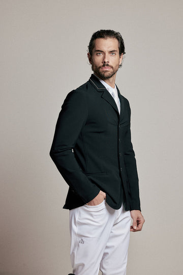Back view of a male rider wearing a black VEL DE REIS equestrian show jacket with white breeches and tall black boots