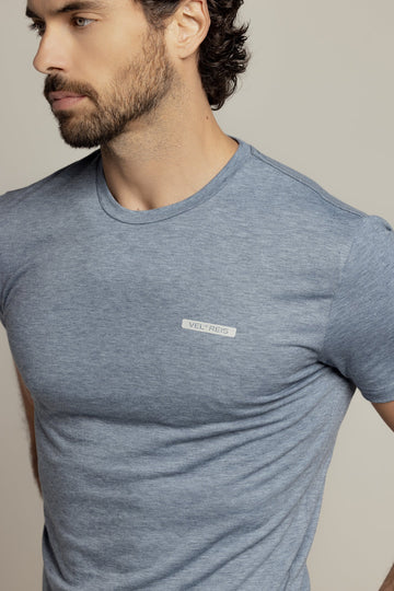 Close-up of a male rider wearing a heathered blue-grey VEL DE REIS training t-shirt