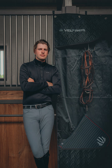 Man standing next to a Vel-Reis product display with equestrian equipment.