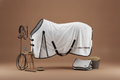 White horse fly blanket with black straps on a brown background, featuring the brand 'VEL DE REIS'.