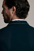 Close-up back view of a man wearing a dark teal-green textured knit polo shirt with a white collar and thin gold stripe detail on the collar.