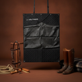 Black Stable curtain with storage and quilted pattern, brown boots, and equestrian equipment on a brown background
