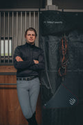 Man standing in front of a black Vel-Reis Stable Curtain with equestrian Tack.