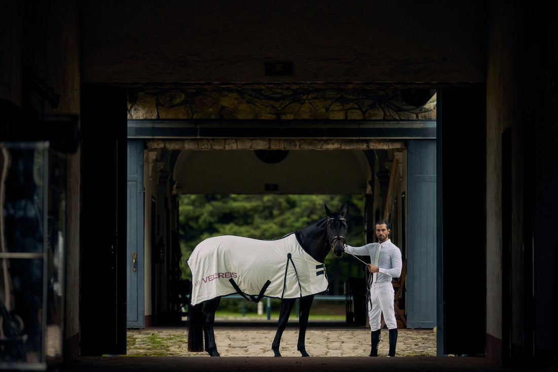 White horse fly blanket with black straps on a brown background, featuring the brand 'VEL DE REIS'.