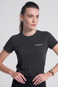 Woman wearing a Charcoal grey t-shirt with a logo on a light gray background