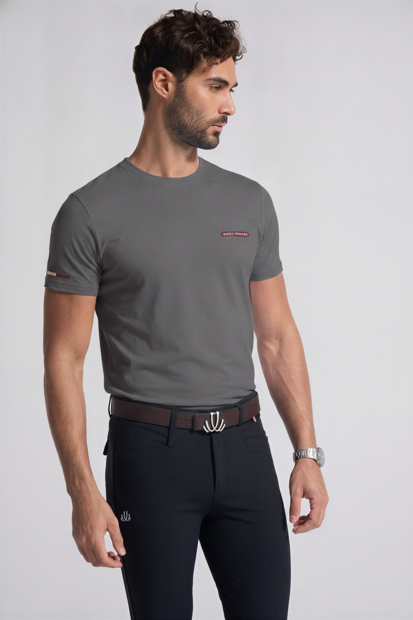 Man wearing a VEL DE REIS gray t-shirt with a small Burgundy logo and black breeches  on a light gray background