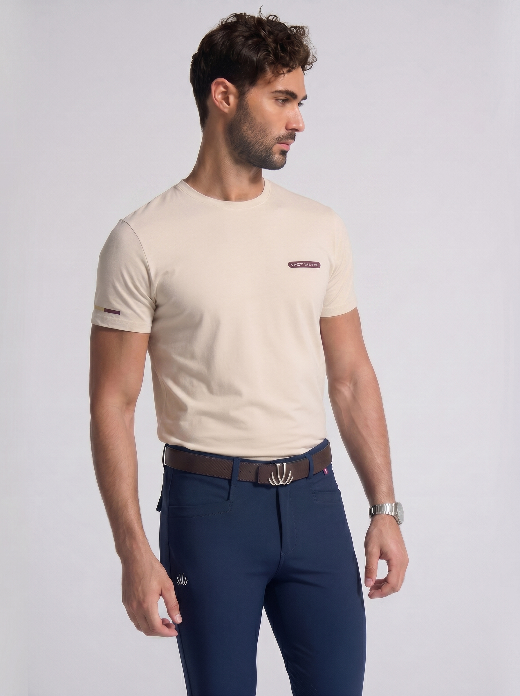 Man wearing a beige t-shirt and navy VEL DE REIS breeches on a light gray background
