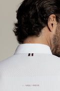 Close-up back view of a man wearing a white textured collared shirt with a small dark double-stripe detail at the collar and 'VEL REIS' printed near the lower back.
