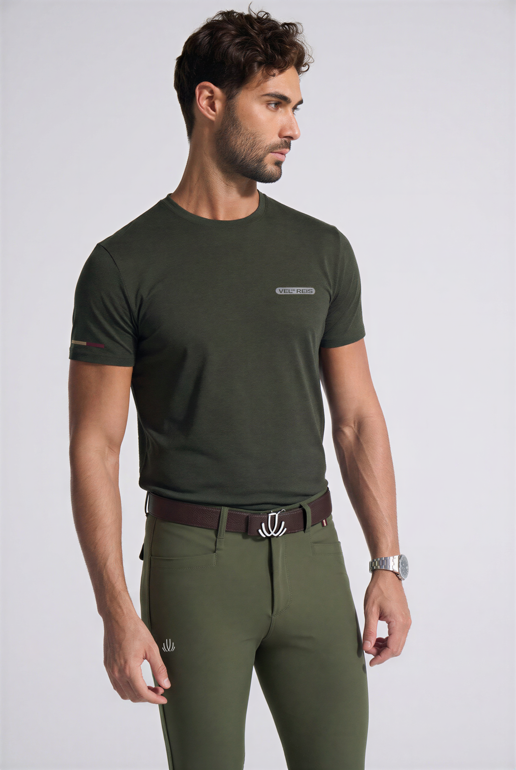 Man wearing a VEL DE REIS green t-shirt and green riding pants on a white background