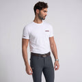 Man wearing a white t-shirt and gray pants on a light gray background