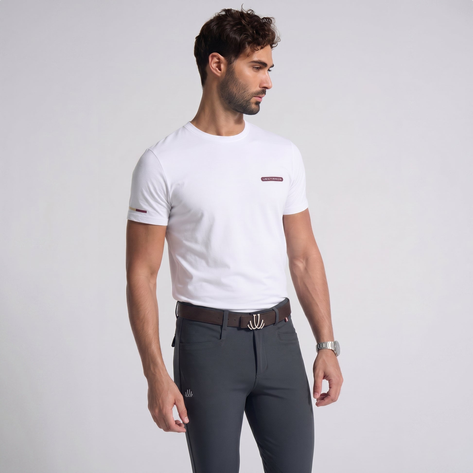 Man wearing a white t-shirt and gray pants on a light gray background