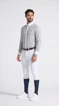 Man wearing a gray sweater, white pants, and navy socks on a white background