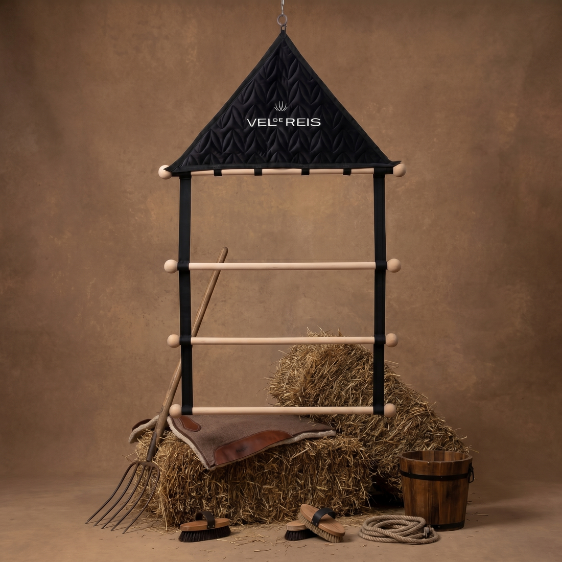 Horse stable with hay, tools, and a saddle  pad hanger from VEL DE REIS on a brown background