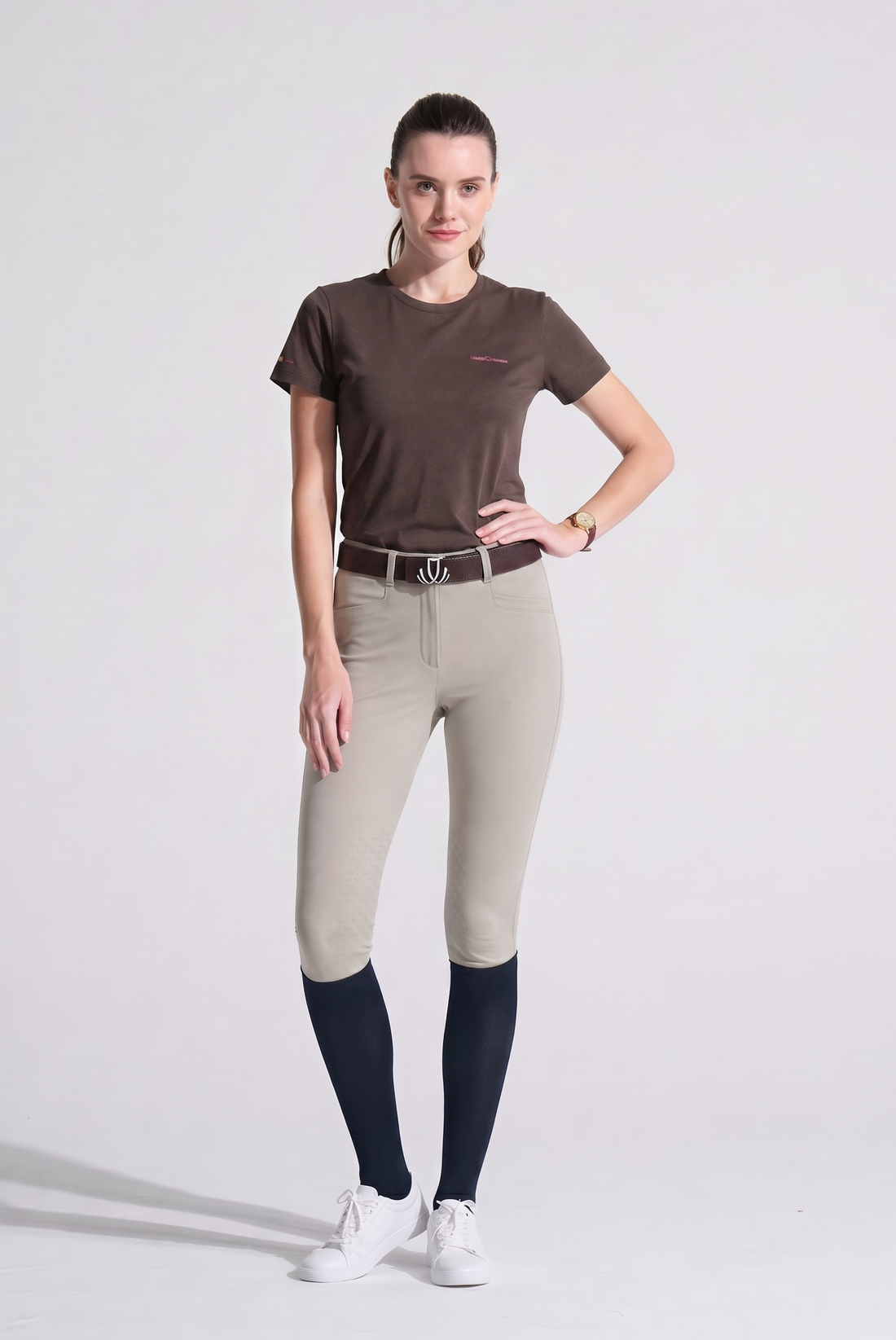 Woman wearing a Charcoal grey t-shirt with a logo on a light gray background