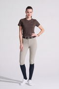 Woman wearing beige riding pants and Brown VEL DE REIS T-Shirt 