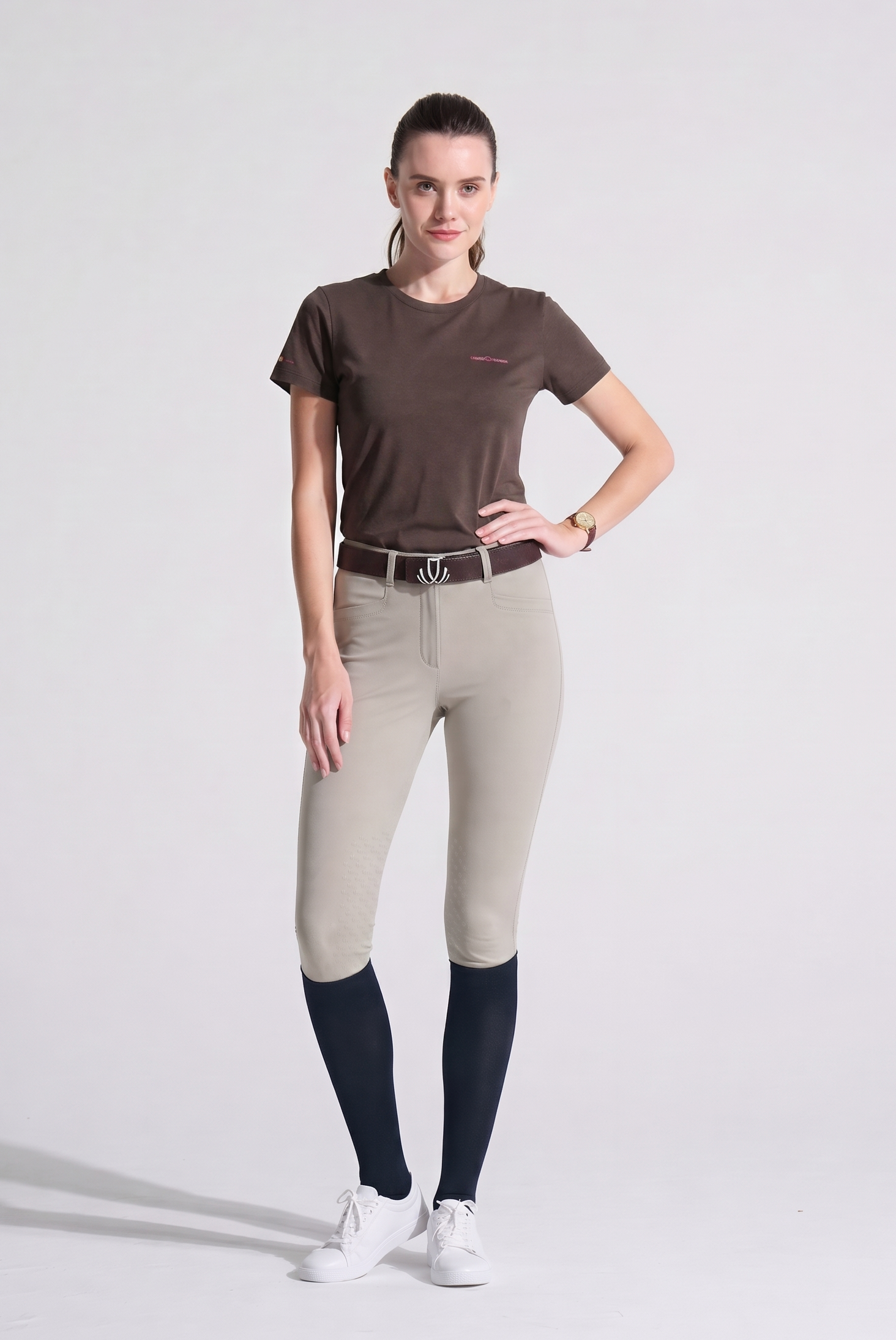 Woman wearing beige riding pants and Brown VEL DE REIS T-Shirt 